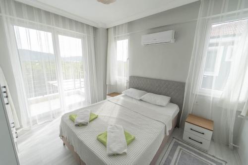una camera da letto bianca con un letto e due finestre di Villa Maya a Çayılı