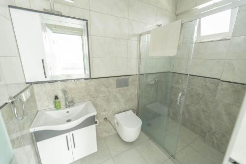un bagno con doccia, lavandino e WC di Villa Maya a Çayılı