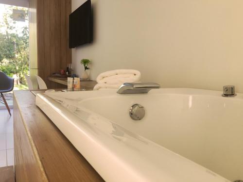 a white bath tub in a room with a chair at Live Hotel Boutique (Adults only) in Punta del Este