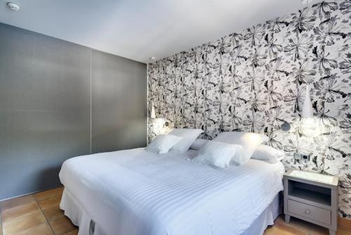 a bedroom with a white bed with a floral wallpaper at Occidental Playa de Palma in Playa de Palma
