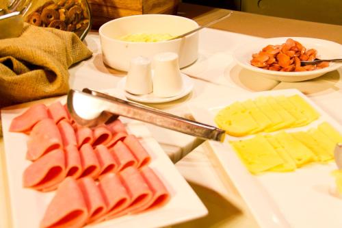 a table topped with cheese and meats and other foods at Hotel Jardines de Uyuni in Uyuni