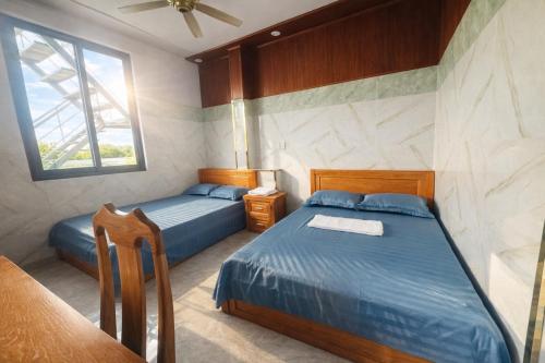 een slaapkamer met twee bedden en een raam bij Bình Cơ Hotel in Hoi Nghia
