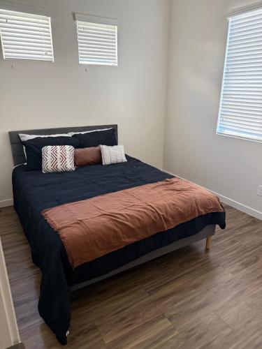 a large bed in a room with two windows at 3 bedroom private villa in Phoenix