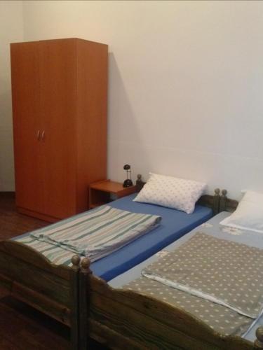 a bedroom with two twin beds and a cabinet at La Principessa in Oradea