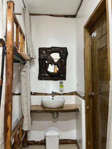 a bathroom with a sink and a mirror on the wall at The Hat Trick Hostel in Basdiot