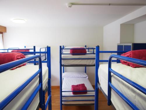 a room with three bunk beds in a room at Albergue Segunda Etapa in Zubiri