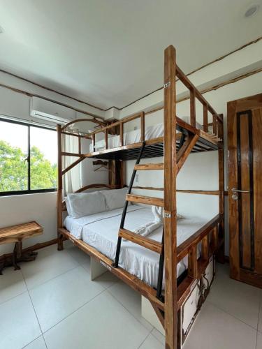 a bedroom with two bunk beds and a desk at The Hat Trick Hostel in Basdiot