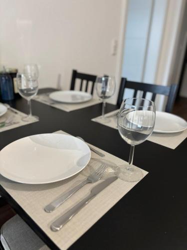 un tavolo con piatti e bicchieri da vino sopra di Ferienwohnung Friesenglück a Wangerland