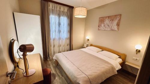 a bedroom with a bed and a window and a lamp at Central Station Apartments in Podgorica