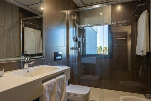 a bathroom with a sink and a toilet and a shower at Sevilla Green Suites in Alcalá de Guadaira