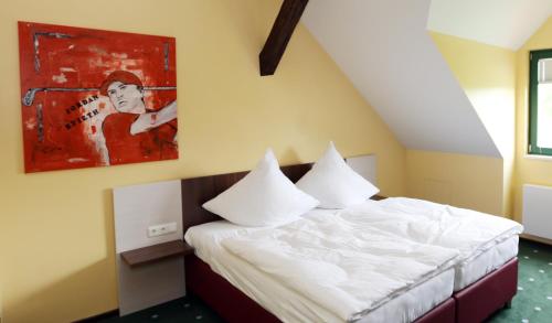 ein Schlafzimmer mit einem Bett und einem Wandgemälde in der Unterkunft Apartments Golfpark Schlossgut Sickendorf in Lauterbach