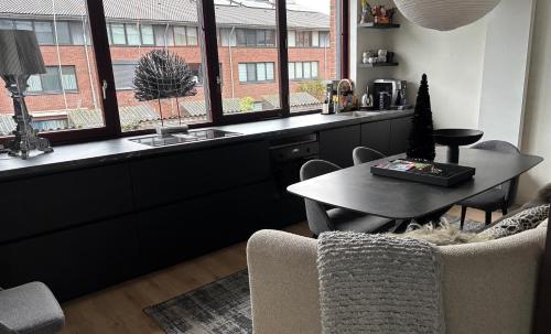 a living room with a table and a window at Near Amsterdam and airport, 90m2, privacy! in Hoofddorp