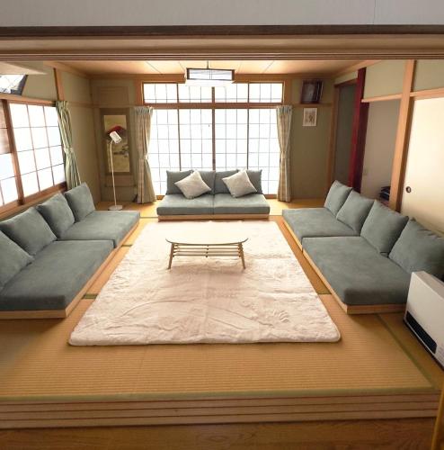 a living room with couches and a coffee table at Sugi Mountain House in Myoko
