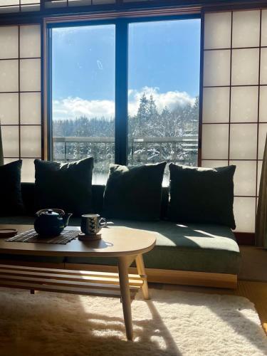 a living room with a couch and a table at Sugi Mountain House in Myoko