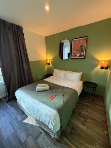 a bedroom with a large bed in a room at Hotel de Berne in Nice