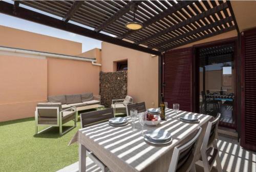 a patio with a table and chairs and a couch at Tajora House by Best Holidays Fuerteventura in La Oliva