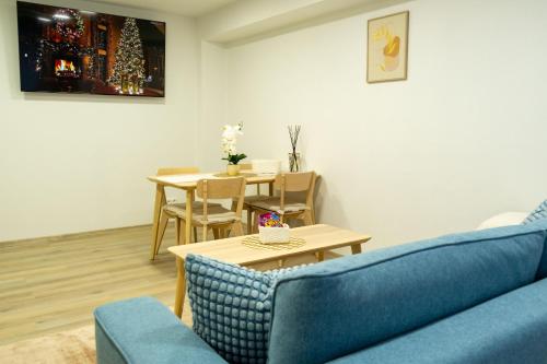 a living room with a blue couch and a table at Apartments Kolín II & Penzion Navara in Kolín
