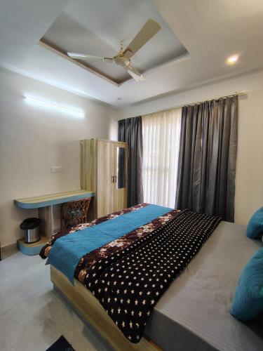 a bedroom with a large bed with a ceiling fan at Gungun Homestay in Rishīkesh