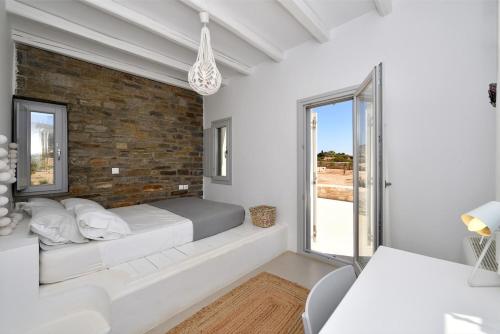 een slaapkamer met een bed en een bakstenen muur bij Villa Apa Calma in Kampos Paros