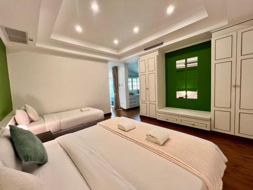 een slaapkamer met twee bedden en een groene muur bij Abode Boutique Resort - Hua Hin in Hua Hin