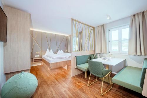 a hospital room with a bed and a table and chairs at Crystls Aparthotel in Flachau