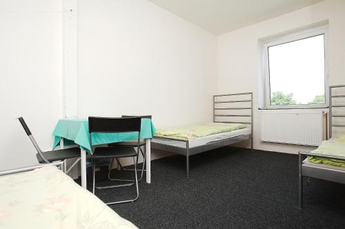 a room with two beds and a table and chairs at Hostel ABEX in Prague
