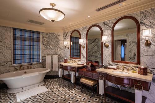 a bathroom with two sinks and a tub and mirrors at Villa Morriss Residence - D'CONG Heritage in Shanghai