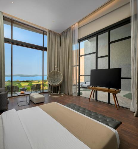 a bedroom with a large bed and a flat screen tv at Aria Resort & Spa in Nashik