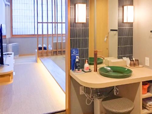 una stanza con una scrivania con un piatto verde sopra di Ayameya Ryokan a Nakanojo