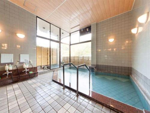 a large bathroom with a large swimming pool at Ayameya Ryokan in Nakanojo