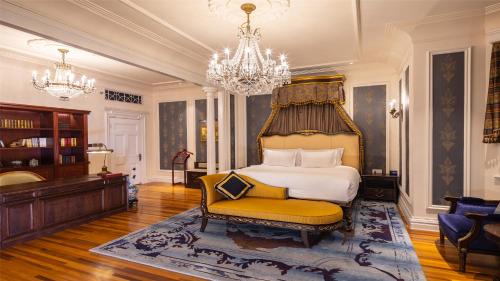 a bedroom with a bed and a chair and a chandelier at Villa Morriss Residence - D'CONG Heritage in Shanghai