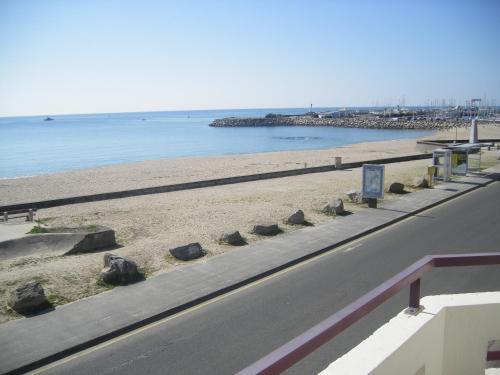 a road next to a beach next to the water at Les Chants d'Ailes - Hôtel Face Mer in La Turballe
