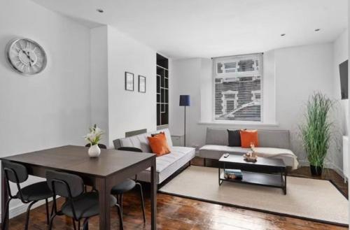 a living room with a couch and a table at Hot Tub Emerald Escape - Private Garden & Free Parking in Cardiff