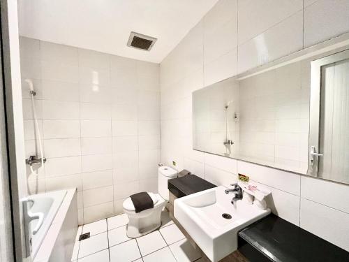 a white bathroom with a sink and a toilet at Hotel Candi Indah Akpol Semarang in Semarang