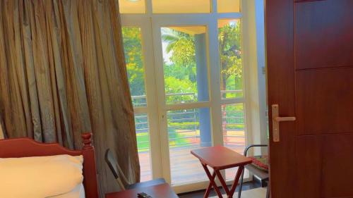 a bedroom with a window and a bed and a chair at Garden house in Kajansi