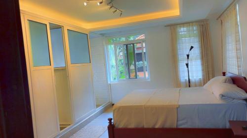 a bedroom with a bed and a window at Garden house in Kajansi