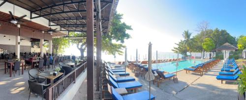 een resort met een zwembad met blauwe stoelen en tafels bij The Hive Hotel in Lamai