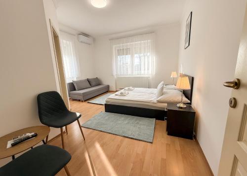 een kleine slaapkamer met een bed en een bank bij Zama Apartman in Hajdúszoboszló