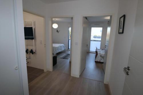 einen Flur mit einem Zimmer mit einem Bett und einem Spiegel in der Unterkunft L'Aigue Marine by TAH - Top emplacement & Parking in Pornichet