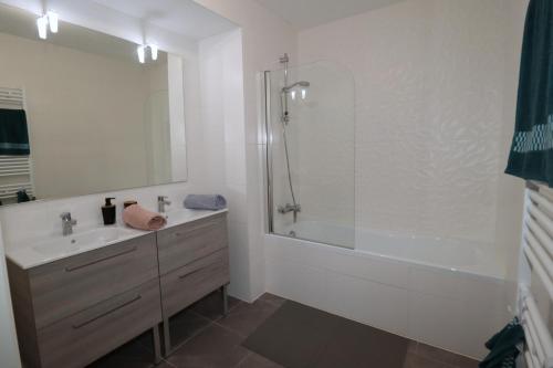 ein Badezimmer mit Badewanne, Waschbecken und Dusche in der Unterkunft L'Aigue Marine by TAH - Top emplacement & Parking in Pornichet