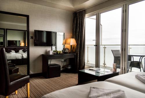a hotel room with a bed and a television at Suncliff Hotel - OCEANA COLLECTION in Bournemouth