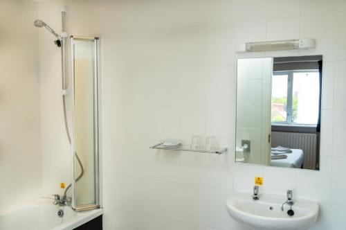 a white bathroom with a sink and a mirror at Suncliff Hotel - OCEANA COLLECTION in Bournemouth