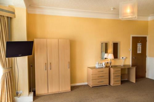 a room with a vanity and a dresser and a mirror at Suncliff Hotel - OCEANA COLLECTION in Bournemouth