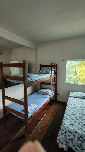 a room with three bunk beds and a window at Coração do Mar in Cayru