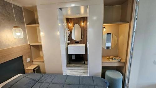 ein Schlafzimmer mit Bett und ein Badezimmer mit Waschbecken in der Unterkunft Camping 4 étoiles - Parc aquatique - ccbcbhg in Caro