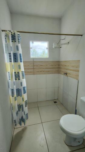 a bathroom with a toilet and a window at Coração do Mar in Cayru
