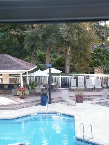 a swimming pool with chairs and a table at Palmera Inn and Suites in Hilton Head Island