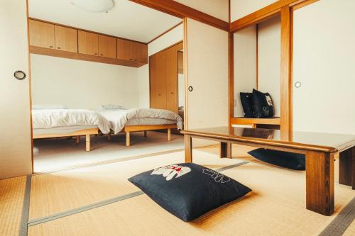 une chambre avec deux lits et un miroir dans l'établissement 南町ハウス, à Biei