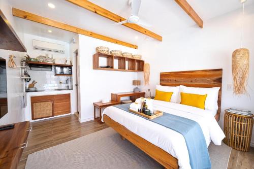 a bedroom with a large bed and a kitchen at The Wander Nest Villas in Panglao Island