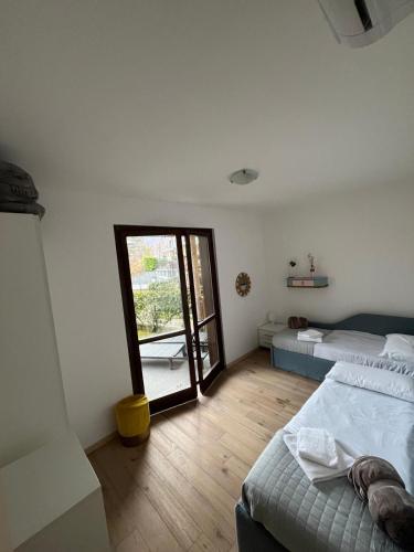 a bedroom with two beds and a sliding glass door at Residence Borgo Castello E1 Apartment in Argegno